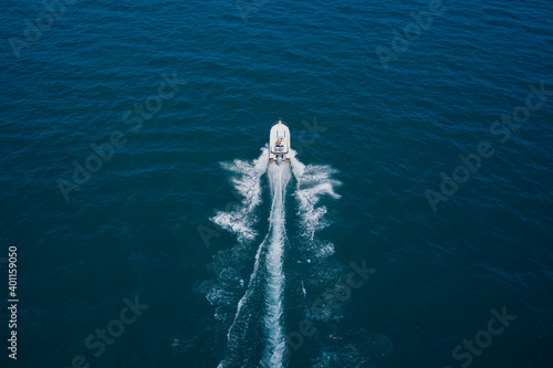 Aerial bird's eye view photo taken by drone of boat. Top view of a white boat sailing to the blue sea. Motor boat in the sea.Travel - image.