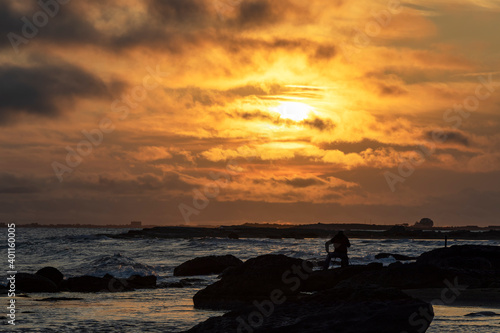 Silhouette of photographer taking pictures of sunrise at the seaside © alexmu