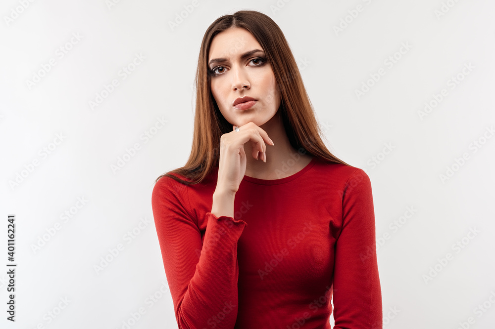 Image of nice serious woman thinking and looking at camera. Human emotions, facial expression concept Image of nice serious woman thinking and looking at camera. Human emotions, facial expression concept