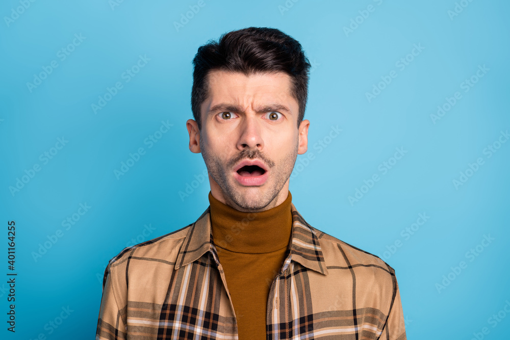 Obraz premium Portrait of young shocked amazed scared afraid speechless man with open mouth isolated on blue color background