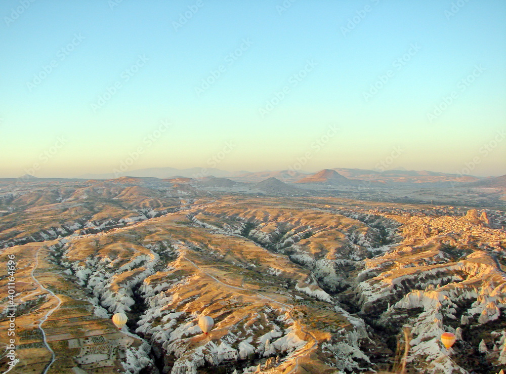 Panorama from above of mountain ranges, snow-white tops of which illuminate the first rays of sunrise.