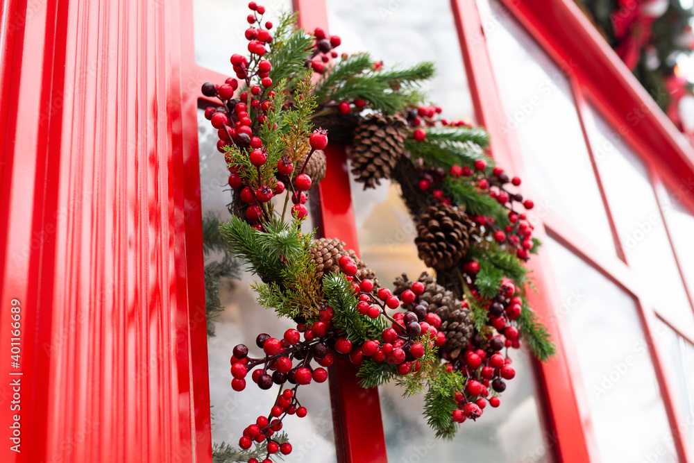 Christmas wreath of red berries, cones and Christmas tree branches on the door.