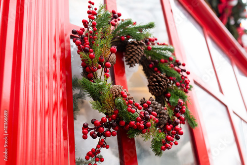 Obraz na płótnie Christmas wreath of red berries, cones and Christmas tree branches on the door. w salonie