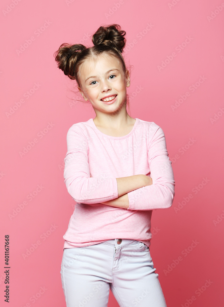 Little girl dressed casually posing on pink background