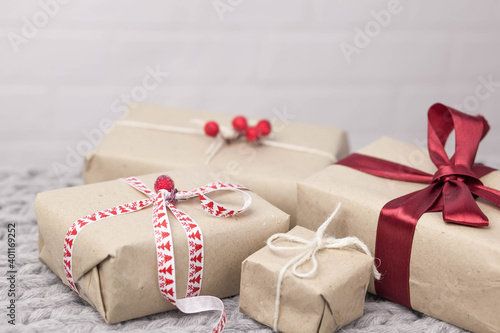 Gift boxes from kafta paper and ribbons on wooden background. Christmas and New Year presents. Birthday greetings and gifts.