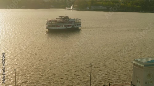 View of passenger boat flaoting on river and flarecraft and submarine at background. Calm sunset in city over Moskva river. photo