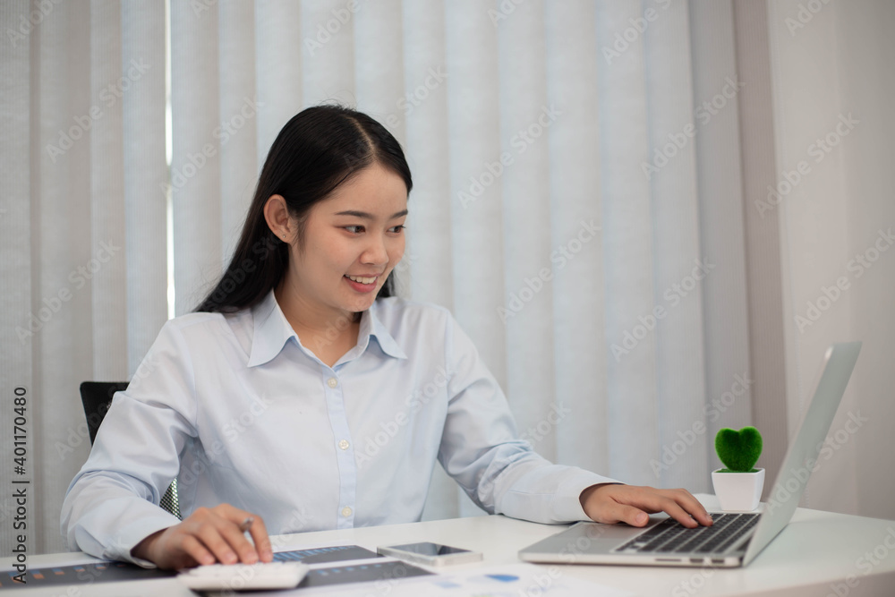 Happy cute pretty accountant working with computer and calculator. Happy cute pretty accountant working with computer and calculator.