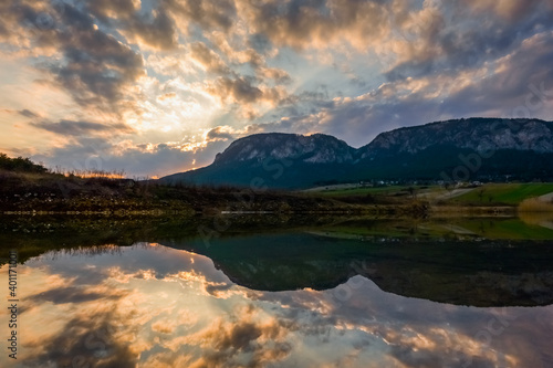 beautiful reflection in a pond with mountains during sunset