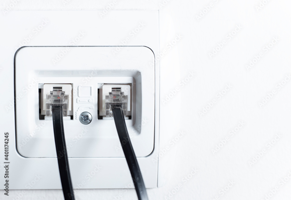 Naklejka premium telephone socket and telephone cable on the wall