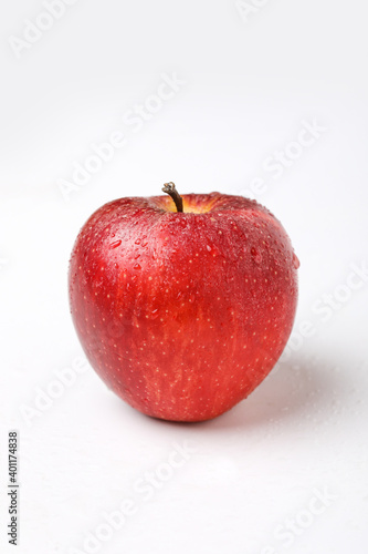 Water drop on fresh red apple on white background