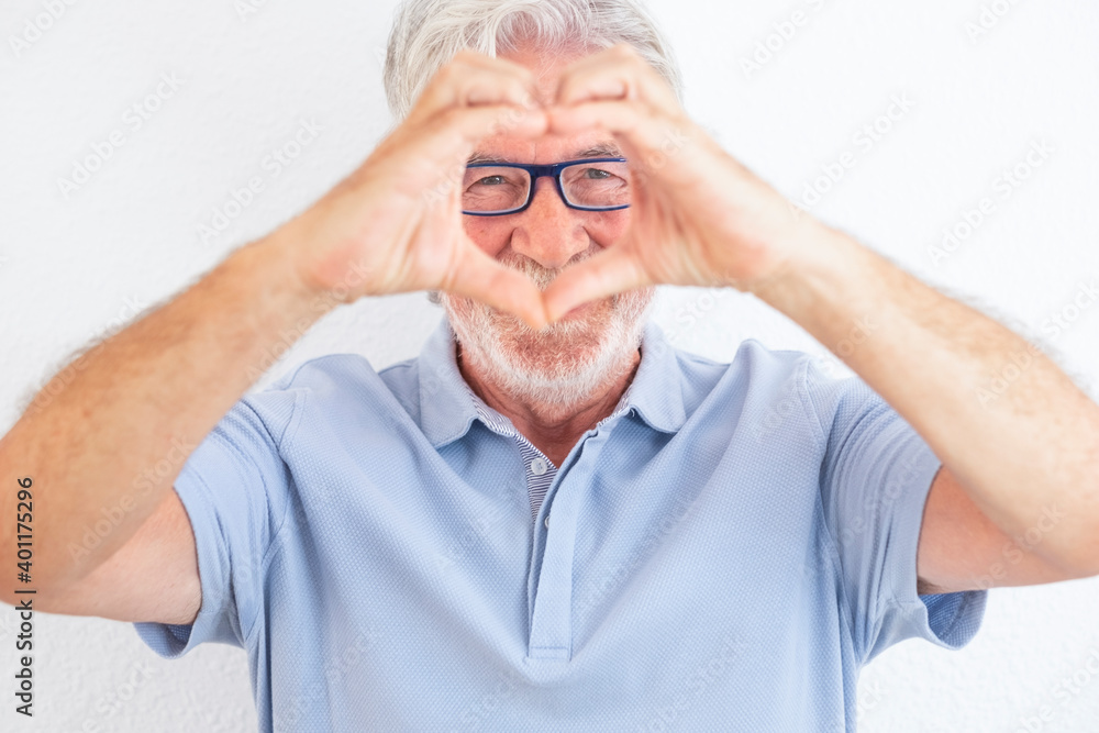 Portrait of a senior white-haired man with eyeglasses looking at camera doing heart shape with hands. Handsome people enjoying retirement, on white background Portrait of a senior white-haired man with eyeglasses looking at camera doing heart shape with hands. Handsome people enjoying retirement, on white background