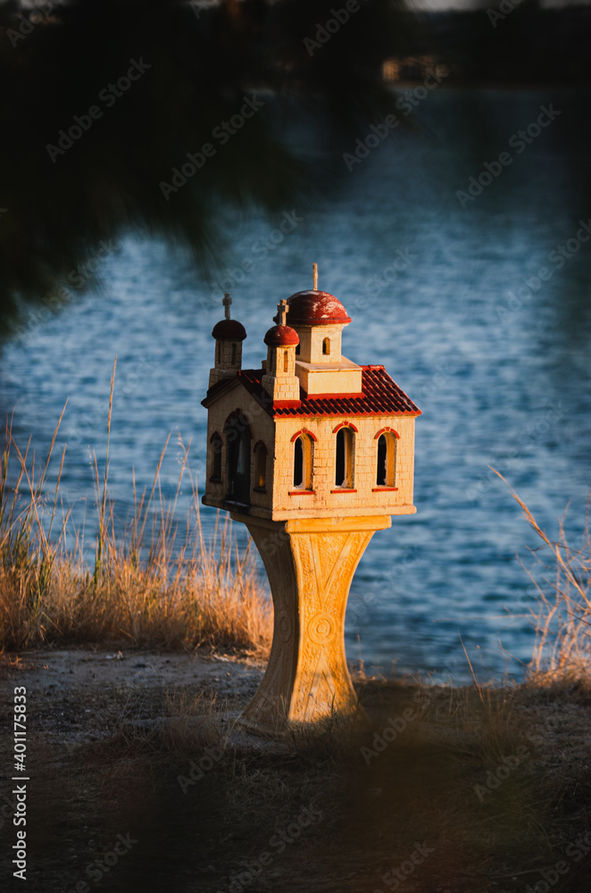 A Greek orthodox miniature church in the sunset at the sea