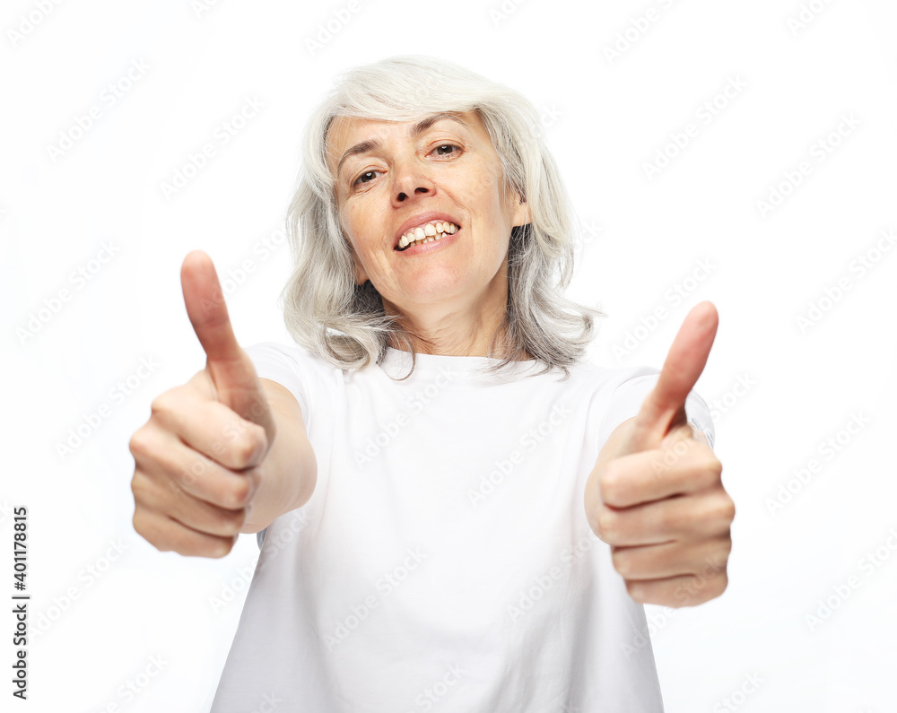 Lifestyle, emotion and people concept: Elderly happy woman giving a thumb up and looking at the camera Lifestyle, emotion and people concept: Elderly happy woman giving a thumb up and looking at the camera