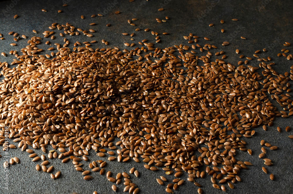 Obraz premium Closeup of heap of dried raw flaxseeds on the dark grey surface