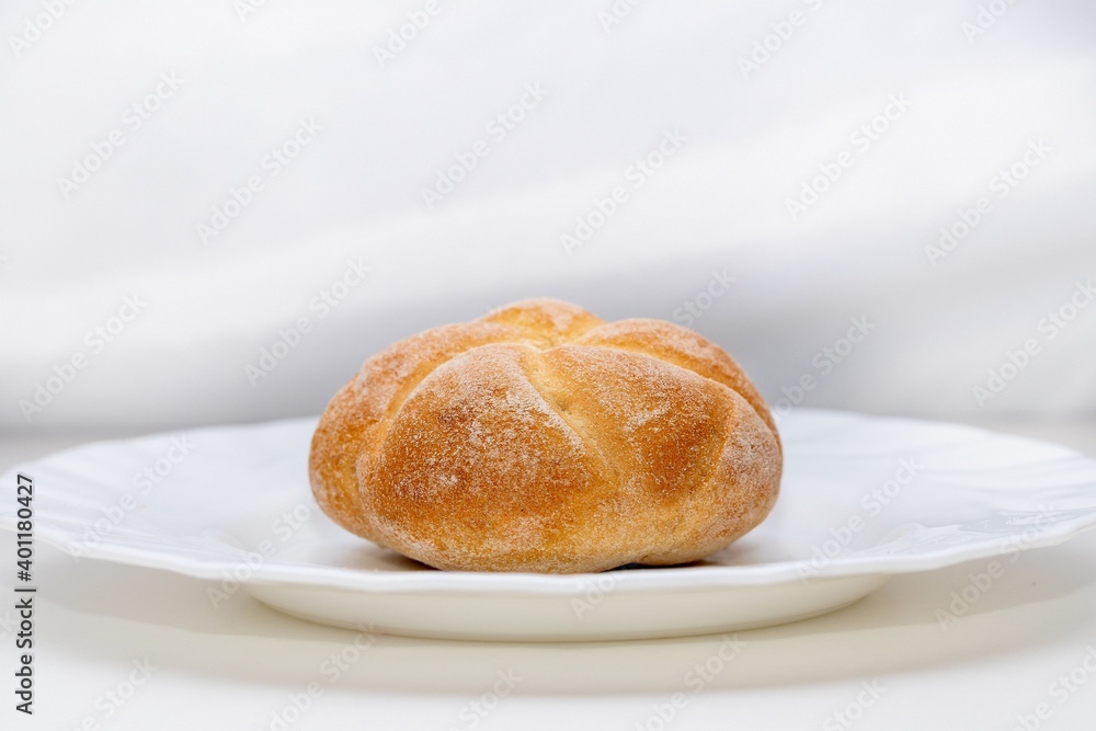 Chubby fresh round bun made of white flour on a plate Chubby fresh round bun made of white flour on a plate
