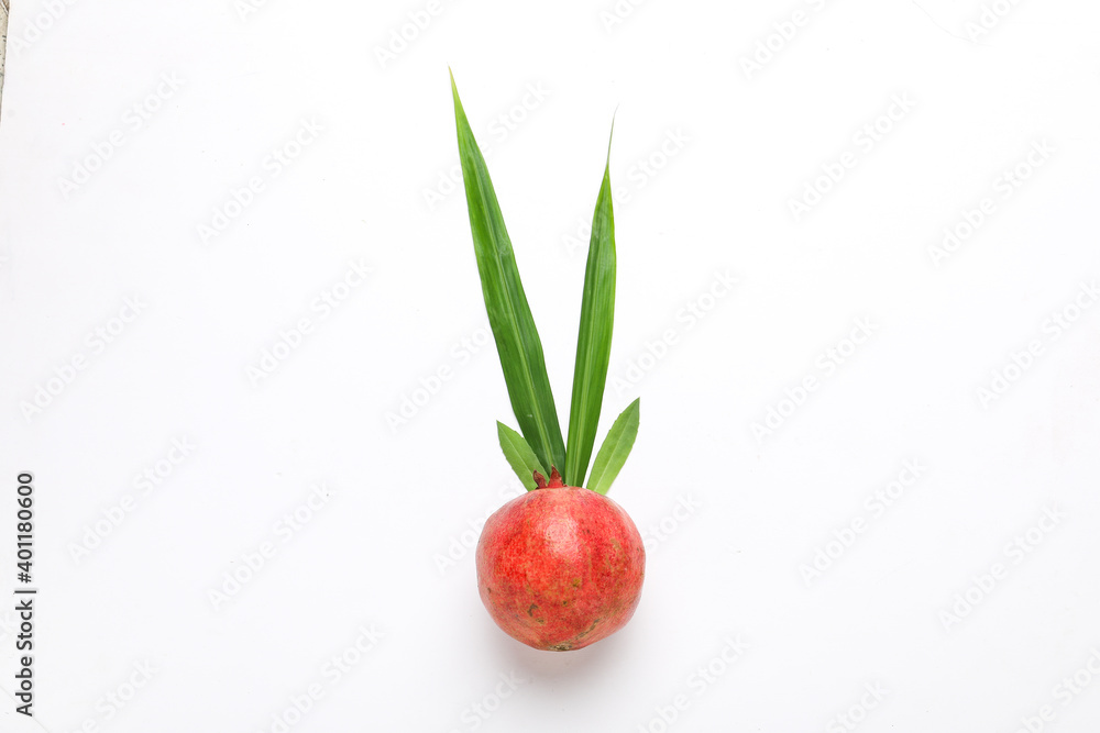 Obraz premium Fresh pomegranate fruit with green leaf on white background