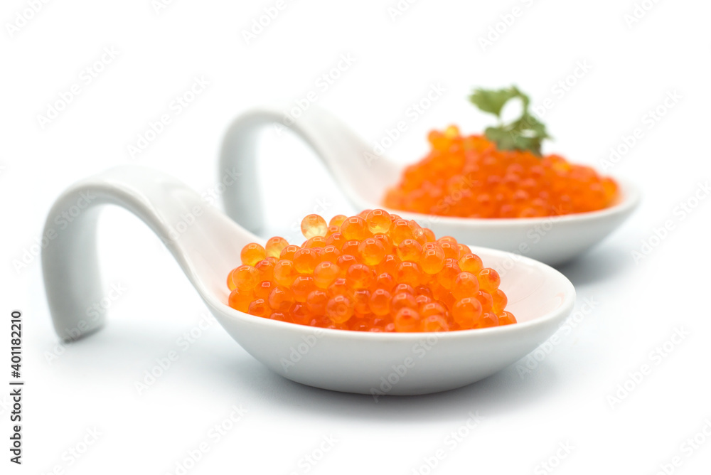 Closeup of trout eggs in a white ceramic spoon on white background Closeup of trout eggs in a white ceramic spoon on white background