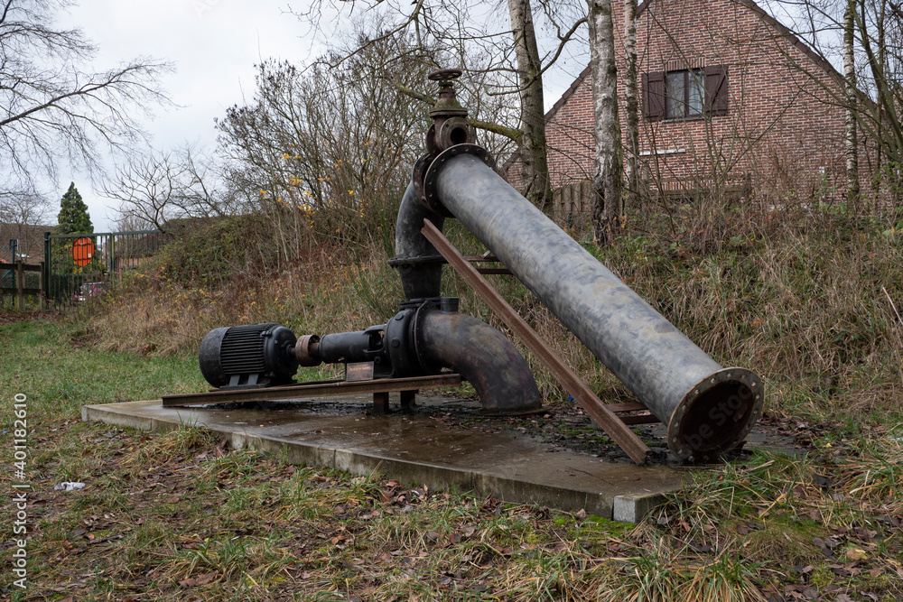 Old pump that pumps rain water in a forest in Stekene, Belgium