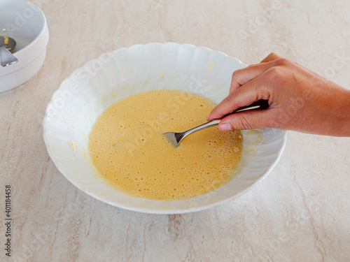 Hand turning the batter of chickpeas for pancakes. Chickpea flour. Vegan recipe photo