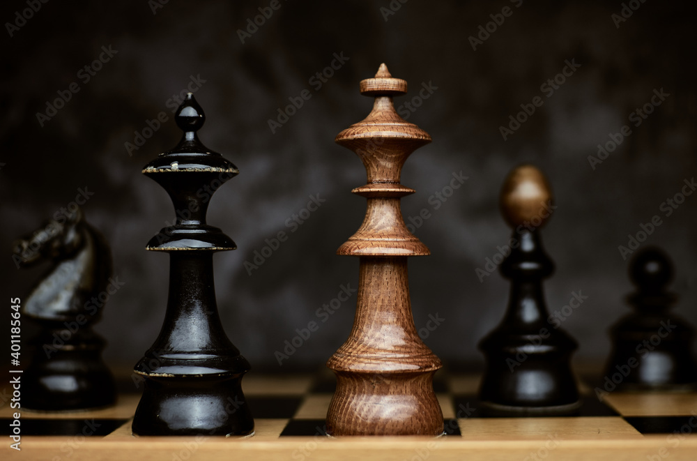 Closeup of a king chess piece checkmate on wooden vintage chessboard Closeup of a king chess piece checkmate on wooden vintage chessboard