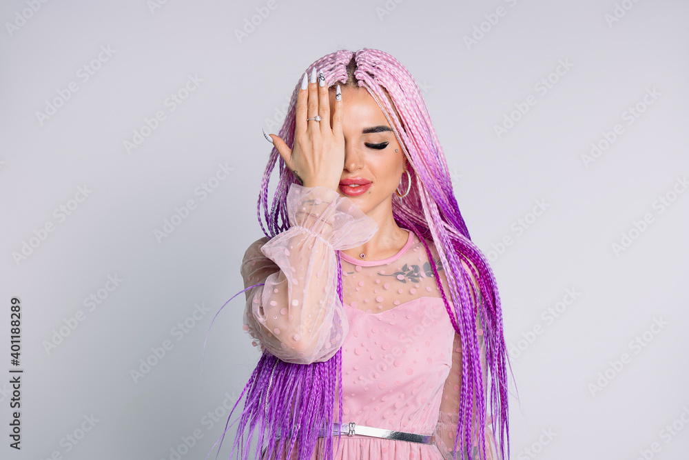 Hipster girl with long pink hair posing with closed eye for camera, covering her eyes with her hand. Hipster girl with long pink hair posing with closed eye for camera, covering her eyes with her hand.