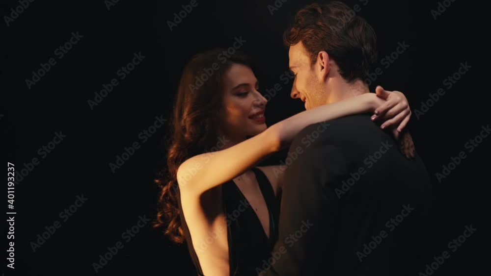 Smiling young couple dancing isolated on black Smiling young couple dancing isolated on black