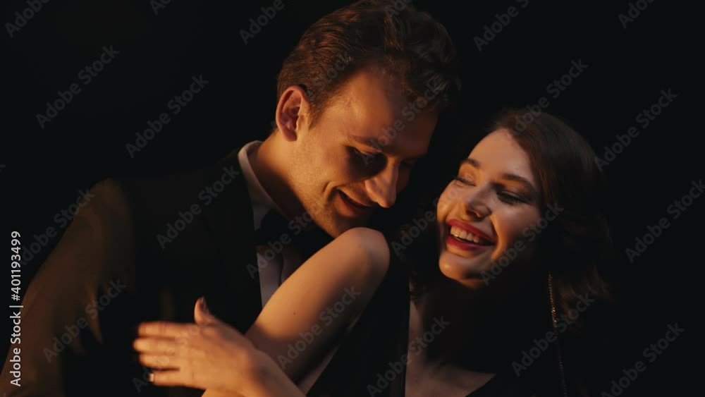 Happy stylish couple dancing isolated on black Happy stylish couple dancing isolated on black