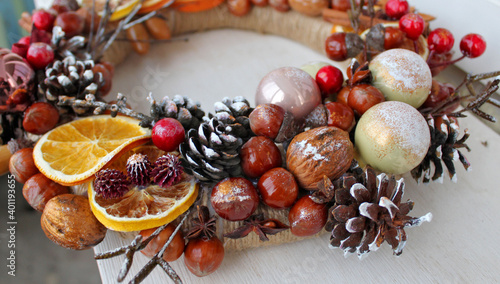 Christmas wreath of pine cones, oranges, nuts, and beads