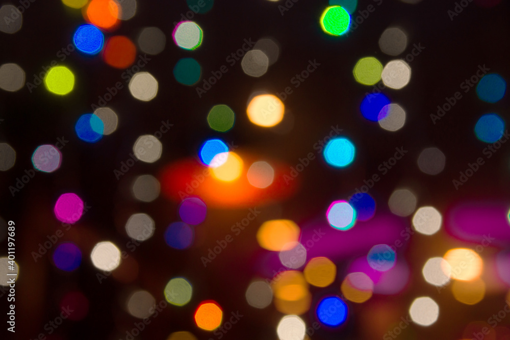 Beautiful multicolored blurred bokeh lights holiday glitter background for Christmas New Years Eve celebration with golden garland sparkling