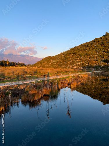 Hills reflection on the surface of the water  pure like a mirror  blue sky background