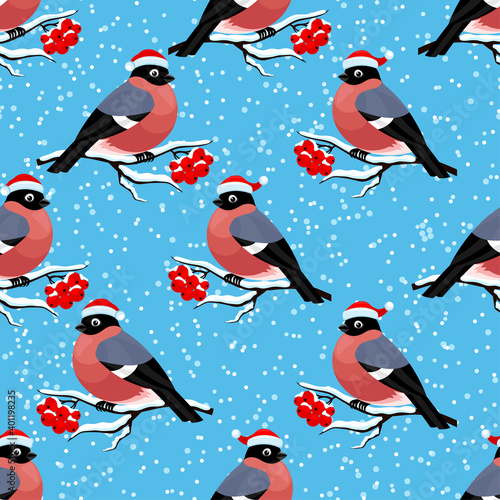 Seamless pattern with bullfinches on rowan branches on a blue background.