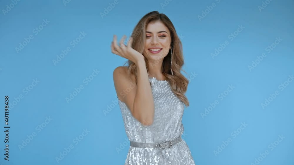 Cheerful woman in dress dancing on blue background Cheerful woman in dress dancing on blue background