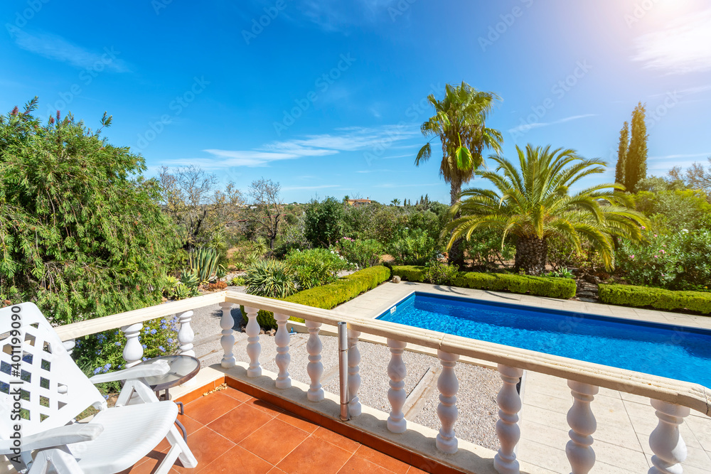 View from the terrace to the luxury pool with clear water in the garden. For tourists. View from the terrace to the luxury pool with clear water in the garden. For tourists.