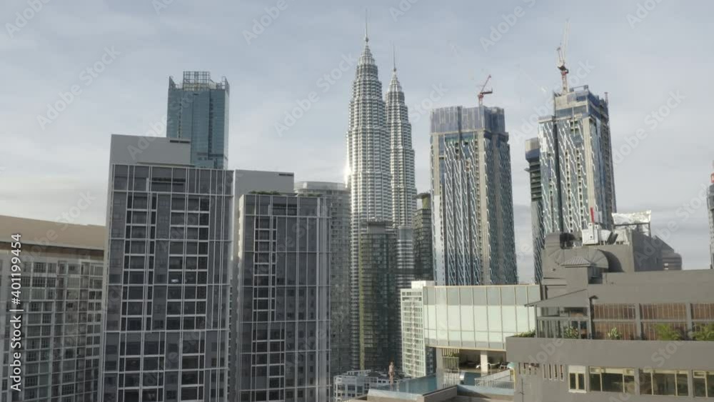 Forward aerial shot of Kuala Lumpur skyline and girl by rooftop pool Forward aerial shot of Kuala Lumpur skyline and girl by rooftop pool