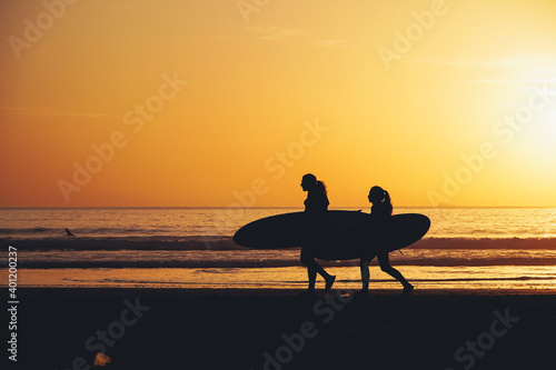 Photography Surfers and people enjoying beach during sunset in Taghazout, Morocco