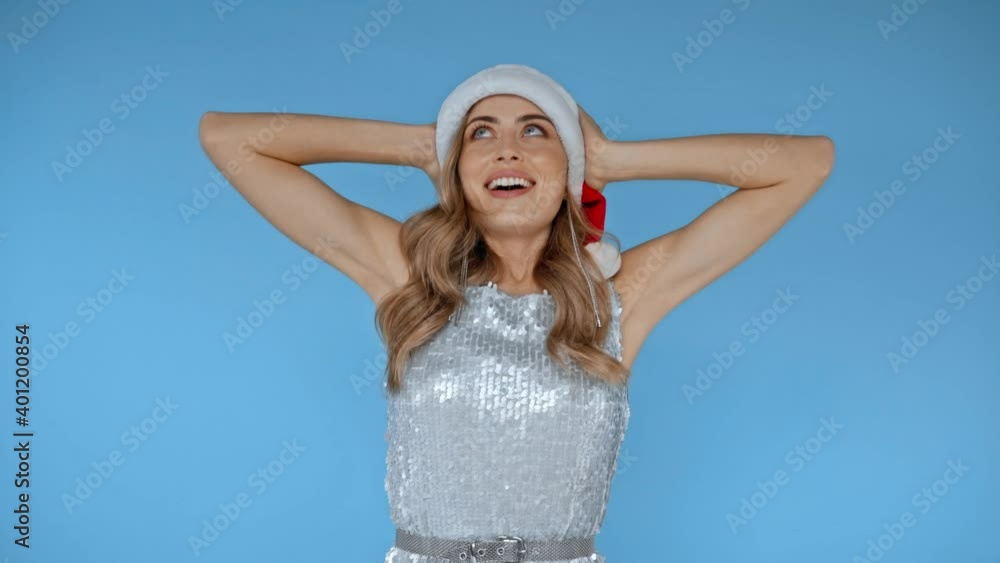 Woman in santa hat throwing medical mask isolated on blue Woman in santa hat throwing medical mask isolated on blue