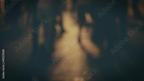 Blurred silhouettes of many pairs dancing in slow motion outside on salsa festivale