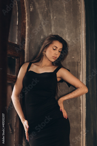 Fashion photoshooting in a photo studio of a beautiful girl in a black dress