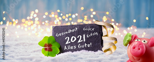 Frohes Neues Jahr 2021  -  Karte zum Neujahr mit Glückwünschen, Glücksklee und Glücksschwein im Schnee photo
