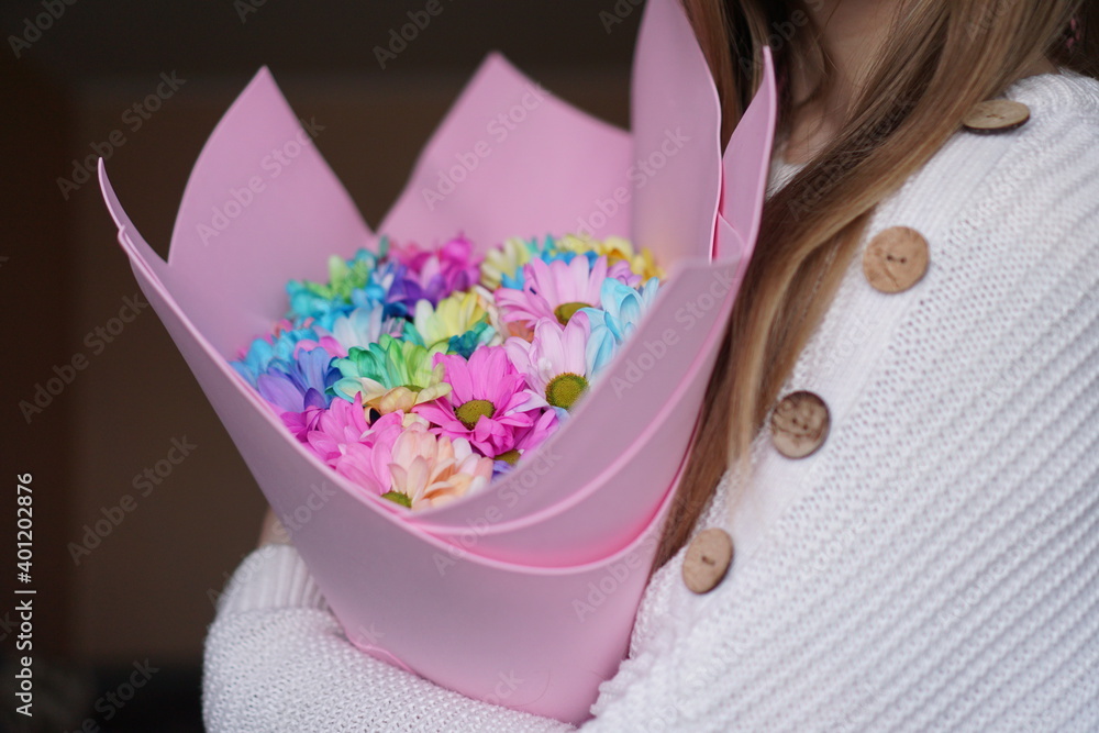 Close up - Woman holding colorful rainbow bouquet in pink packaging