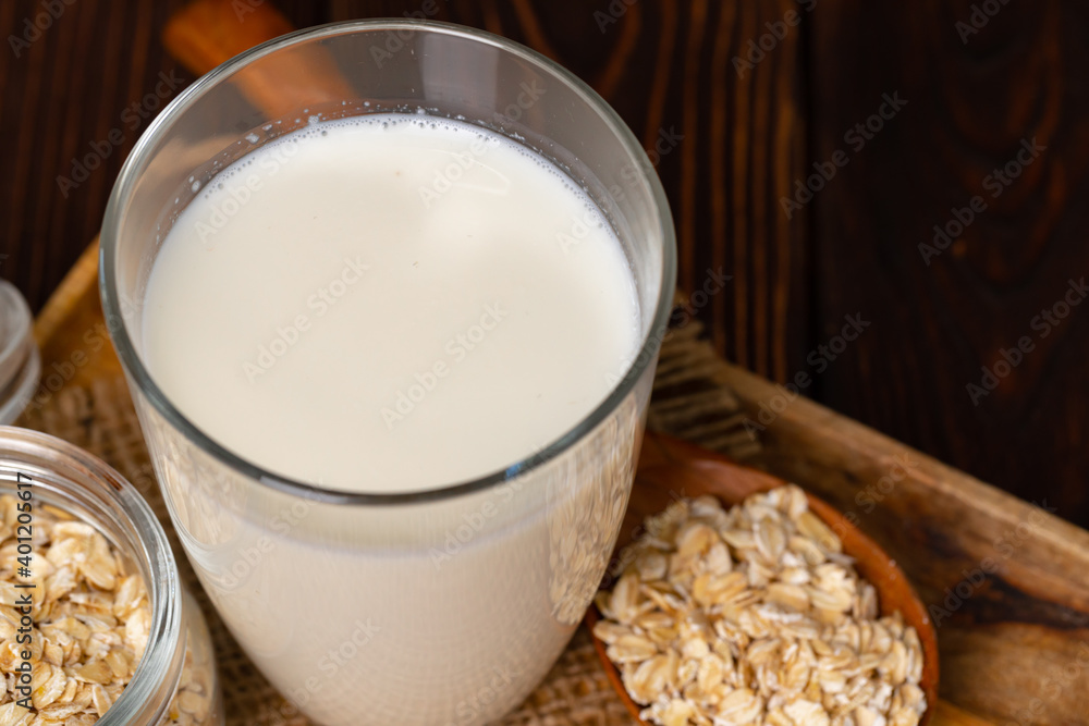 Glass of milk and oat flakes on wooden table Glass of milk and oat flakes on wooden table