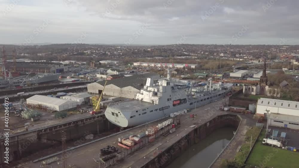 Cammell Laird British industry shipyard aerial view servicing military naval ship Birkenhead skyline right orbit pull back Cammell Laird British industry shipyard aerial view servicing military naval ship Birkenhead skyline right orbit pull back