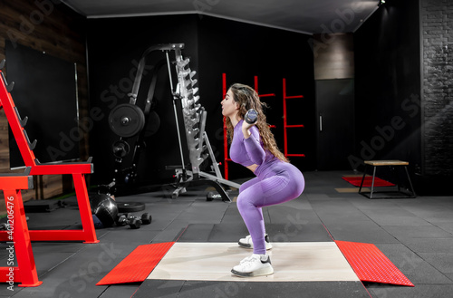 Young girl lifting weights in the gym. Healthy lifestyle concept 
