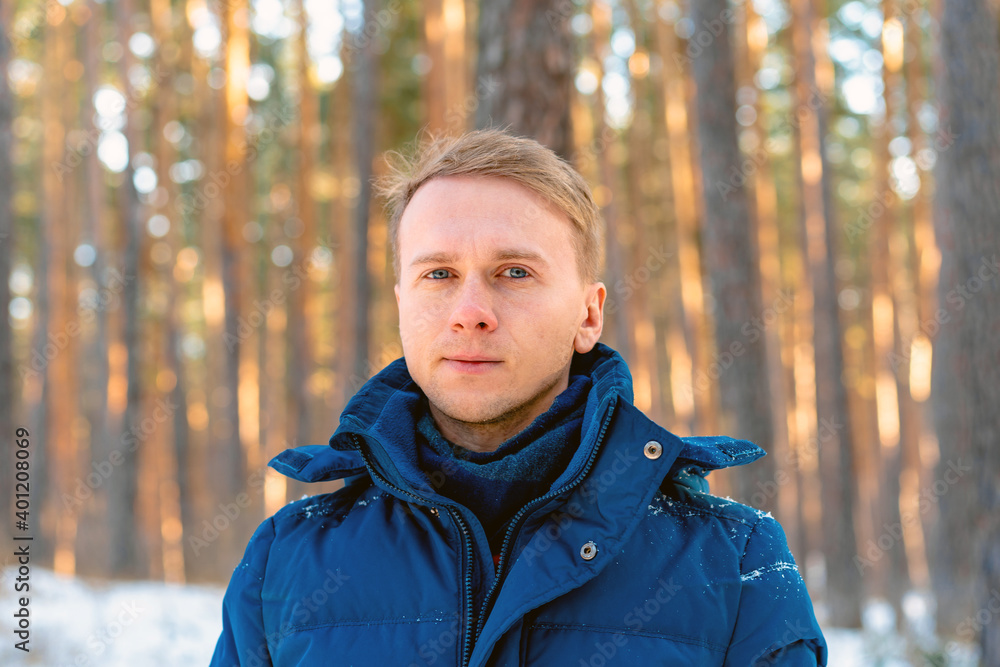 Portrait of a young man on the background of a snowy landscape in a winter pine forest Portrait of a young man on the background of a snowy landscape in a winter pine forest