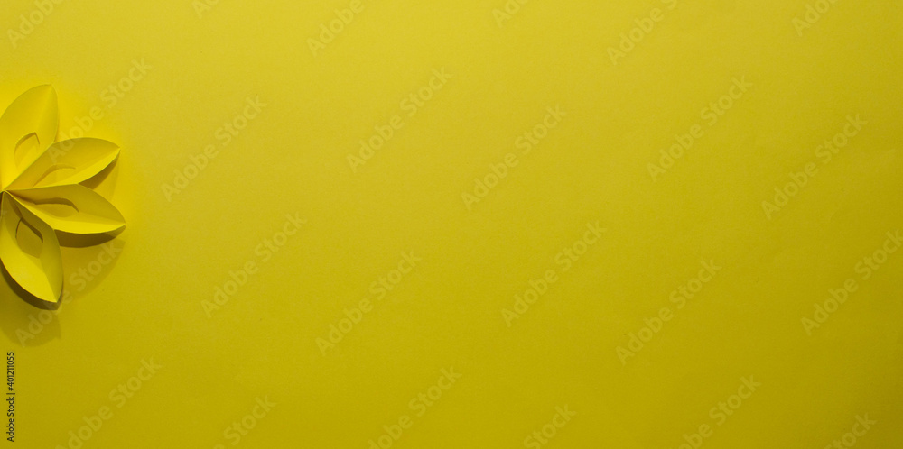 Background of a quarter yellow paper flower on a yellow background.