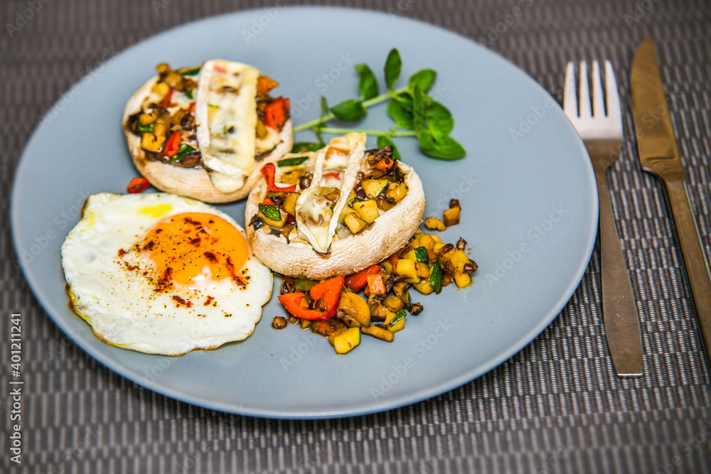 Mushroom stuffed with fresh vegetable mixture and egg. The food in the restaurant. Food styling and restaurant meal serving. Mushroom stuffed with fresh vegetable mixture and egg. The food in the restaurant. Food styling and restaurant meal serving.