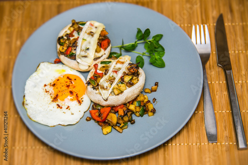 Mushroom stuffed with fresh vegetable mixture and egg. The food in the restaurant. Food styling and restaurant meal serving.