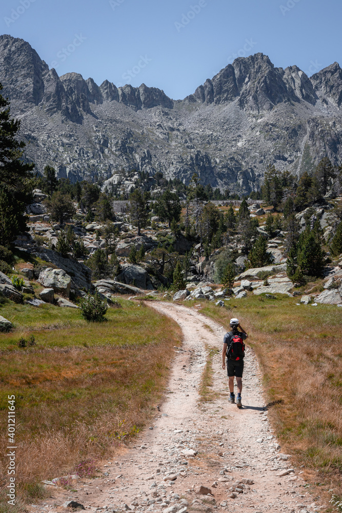 Senderista caminando por un camino en el parque nacional de aiguestortes con vistas a las montañas 