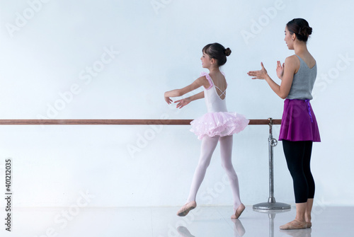 Little ballerina dancing with ballet teacher in dance studio
