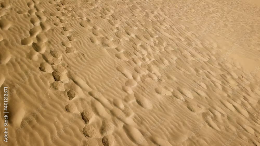 Aerial above sand dune pattern at the desert. Fly over desert landscape with wavy waves sands texture. Dry terrain shadow mist patterns. Aerial above sand dune pattern at the desert. Fly over desert landscape with wavy waves sands texture. Dry terrain shadow mist patterns.